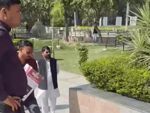 बैटरी बैकअप वाला स्पीकर लाता कर्मचारी