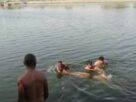 यमुना नदी में लापता युवक की तलाश करते गोताखोर