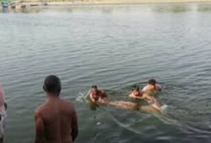 यमुना नदी में लापता युवक की तलाश करते गोताखोर