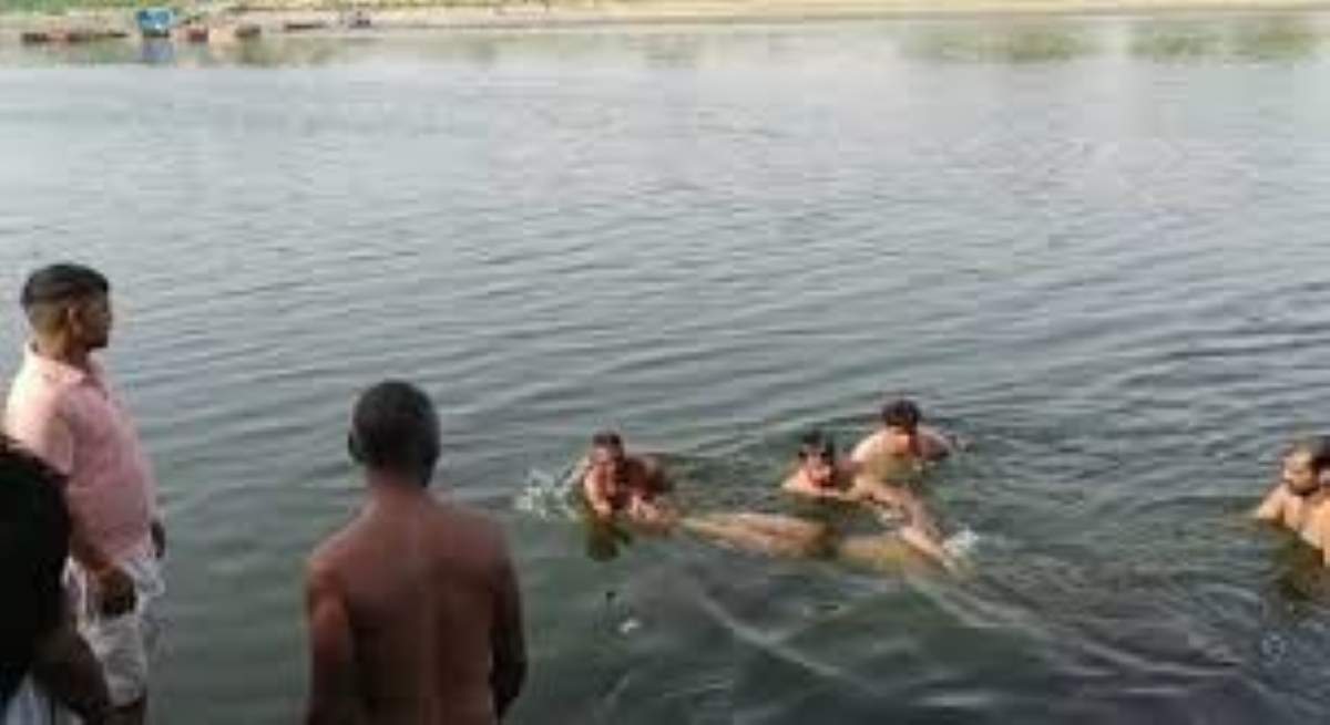 यमुना नदी में लापता युवक की तलाश करते गोताखोर