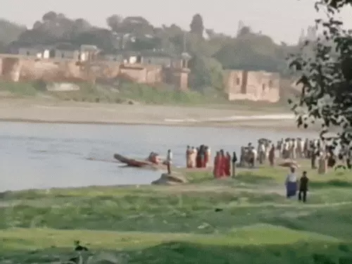 यमुना नदी में लापता युवक की तलाश करते गोताखोर