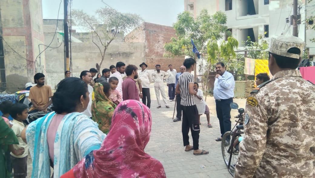 अवैध कब्जाधारियों को चेतावनी देते और मकानों को चिन्हित करते अधिकारी