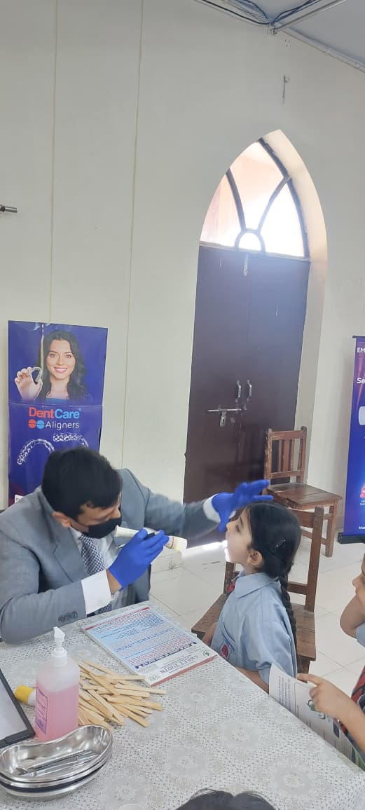 शिविर में कतारबद्ध खड़े होकर अपनी बारी का इंतजार करते स्कूली छात्र