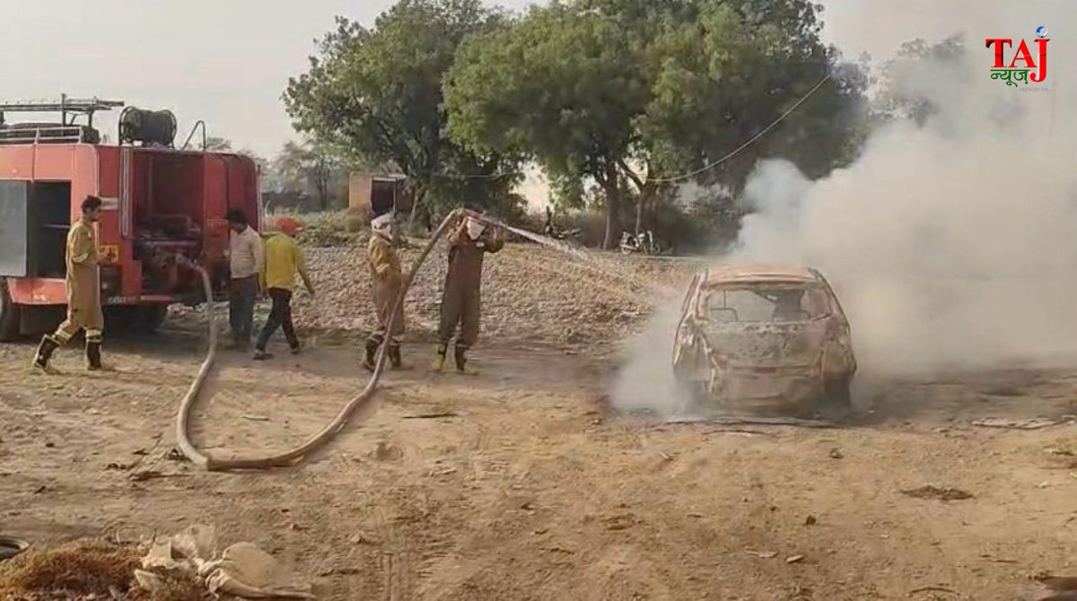 Firefighters dousing fire in a Tata Tiago car caught in flames on the roadside in Saiyan Agra