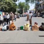 आगरा में पानी के लिए सड़क पर उतरीं महिलाएं: छीपीटोला चौराहे पर जाम लगाकर जताया विरोध, प्रशासन के खिलाफ नारेबाजी Public demonstration layout featuring municipal streets and water utility protest signs in Agra