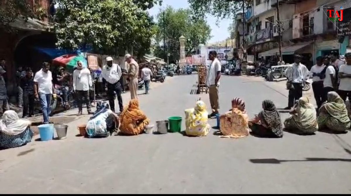 Public demonstration layout featuring municipal streets and water utility protest signs in Agra