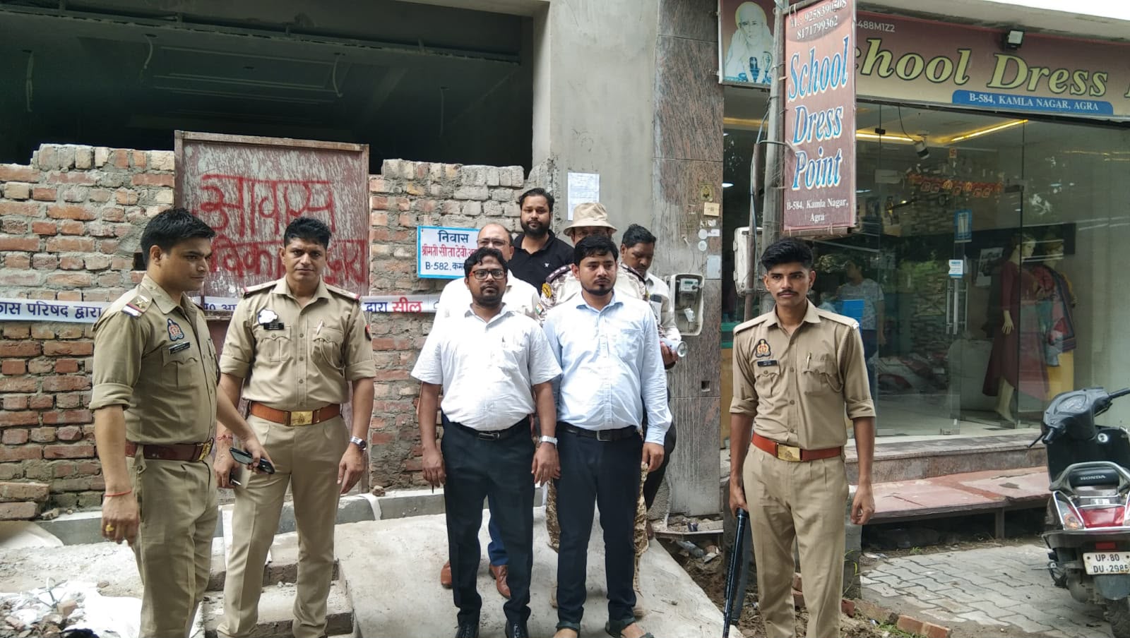 कमला नगर योजना क्षेत्र में नियम विरुद्ध बने भवनों पर सील लगाते आवास विकास के कर्मचारी