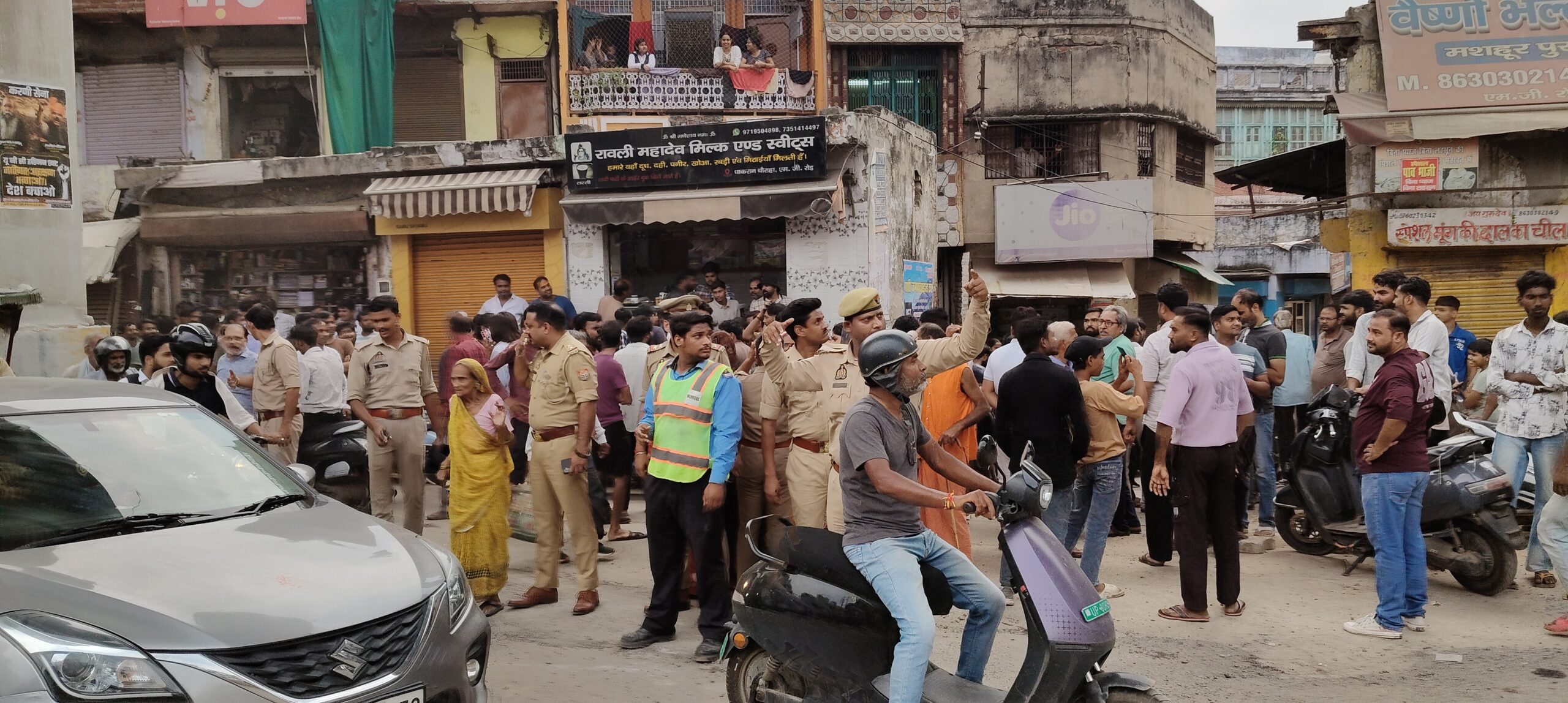 आगरा धाकरान चौराहे पर मेट्रो पिलर पर चढ़ा युवक और नीचे जुटी भीड़